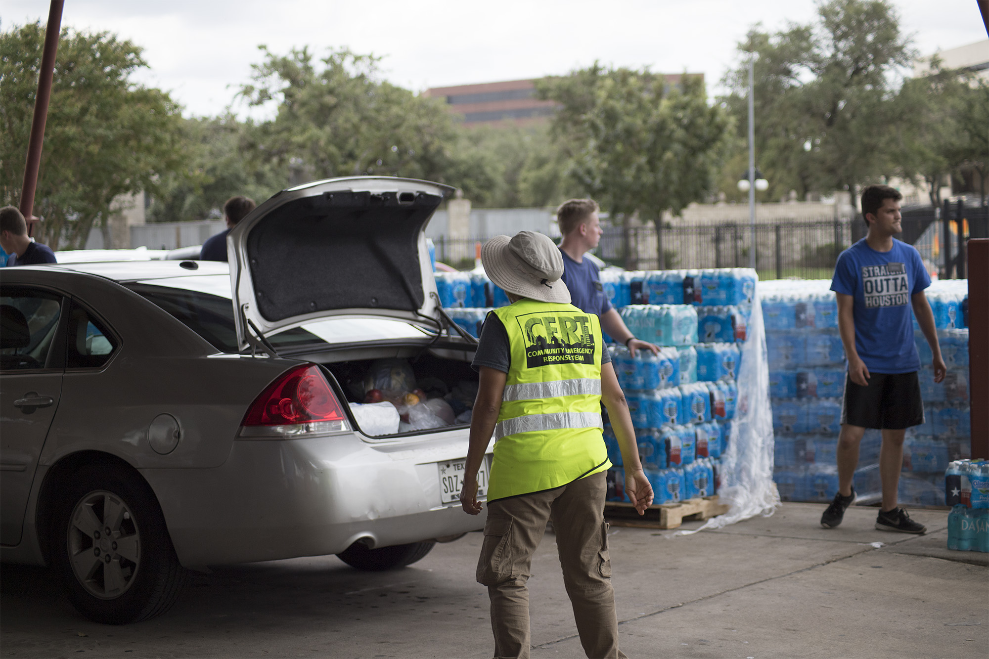 Volunteers hand out water to community members at a drive-through emergency supply distribution center in Houston, July 13, 2024.